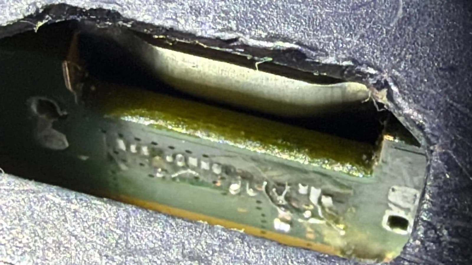 Detail poškozeného HDMI portu PS5 s potrhaným plastem krytu